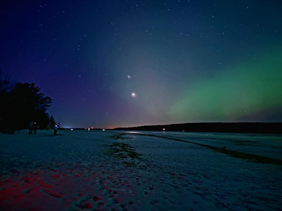 northern lights display above sand point beach in munising