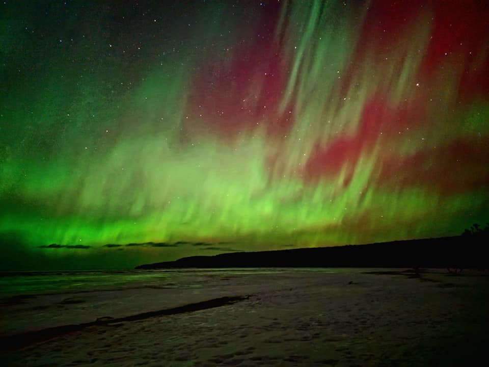 northern lights display on a beach in munising