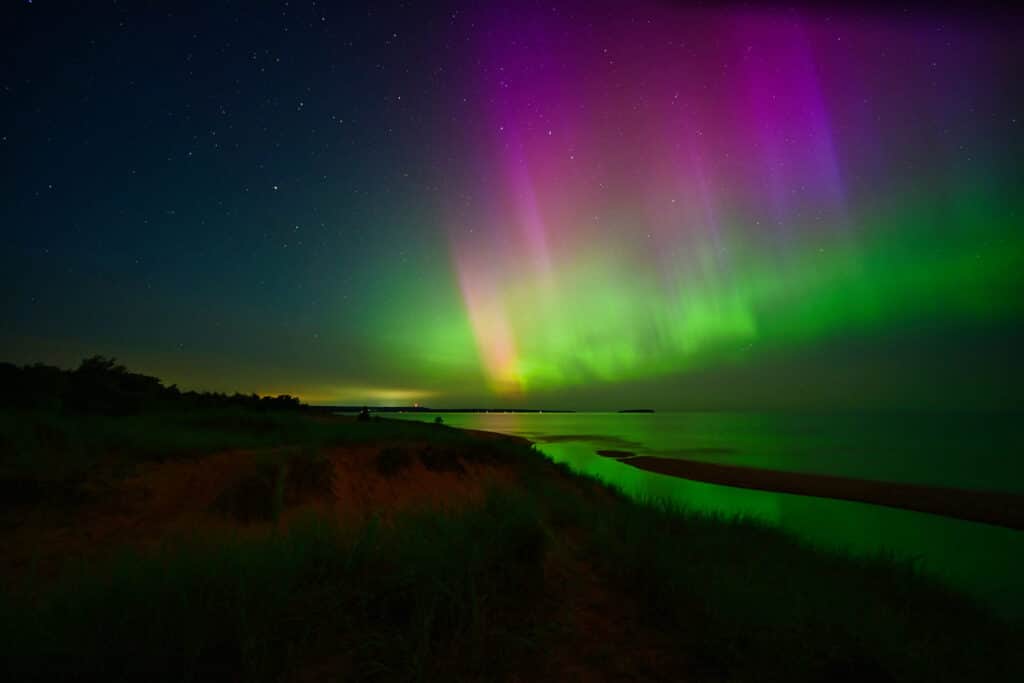 northern lights display above au train beach in munising